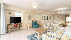 a living room with a couch and a tv at Ocean Bay Club 101 - Oceanfront - Ocean Drive Section in Myrtle Beach