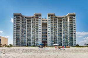 a large building on the beach with people on the beach at Ocean Bay Club 101 - Oceanfront - Ocean Drive Section in Myrtle Beach