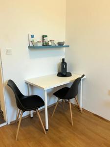 a table and two chairs sitting next to a desk at Studio-Apartment in zentraler Lage in Graz