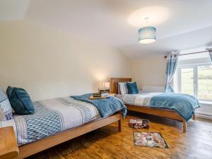 a bedroom with two beds and a window at 3 Bed in Llandrindod Wells 65885 in Llanbadarn-fynydd