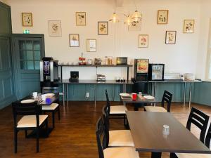 a restaurant with tables and chairs and a kitchen at Hotel du Parc in Dinard +51 photos