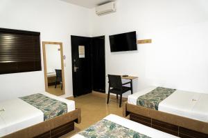 ein Hotelzimmer mit 2 Betten und einem TV in der Unterkunft Hotel Central Plaza Medellin in Medellín