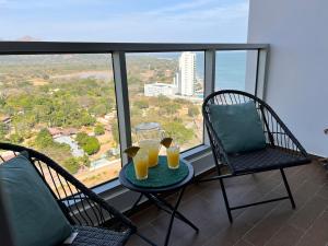 two glasses of orange juice on a table on a balcony at Apartamento de playa con calor de hogar in Nueva Gorgona