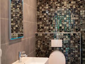 a bathroom with a toilet and a sink and a mirror at Wellness Home w Hot Tub in Hoenderloo +29 photos
