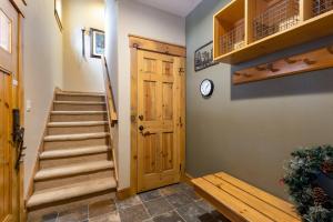 a hallway with a staircase and a wooden door at 6554 Settlers Creek townhouse in Keystone