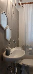 a bathroom with a white sink and a toilet at Home Maro in Lefkimmi +19 photos