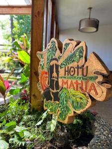 een bord voor een hotel maru maju in een tuin bij Hotel Hotu Matua in Hanga Roa