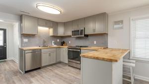 a kitchen with white cabinets and a wooden counter top at Sand Dollar - 3rd Row - Ocean Drive Section in Myrtle Beach