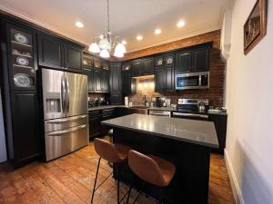 a kitchen with black cabinets and stainless steel appliances at Madison Manor II by the River Hot Tub Downtown in Madison