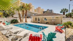 a swimming pool with a bunch of chairs around it at Sand Dollar - 3rd Row - Ocean Drive Section in Myrtle Beach