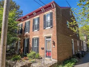 a brick house with a red door on a street at Madison Manor II by the River Hot Tub Downtown in Madison