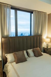 ein Schlafzimmer mit einem großen Bett und einem großen Fenster in der Unterkunft Apto Yoo Vista al Mar in Panama-Stadt