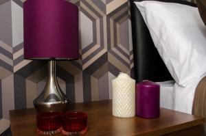 a purple lamp on a table next to a bed at Trivelles Eccles in Manchester
