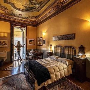 uma mulher a entrar num quarto com uma cama em B&B Palazzo Melluso em Porto Empedocle