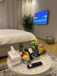 una mesa con patatas fritas y aperitivos en un dormitorio en أستديو قريب من البوليفارد و أهم الأماكن السياحية قفل ذكي, en Riad
