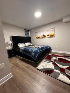 a bedroom with a bed and a rug at Treasure’s Beautiful Basement in Brampton