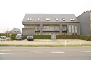 a building with two cars parked in a parking lot at Hotel Apartments Belgium 1 - HAB 1 in Geel