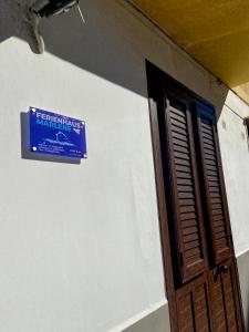 un panneau sur le côté d'un mur à côté d'une porte dans l'établissement Ferienhaus Marlene - Casa Vacanze San Nicola L'Arena, à Trabia