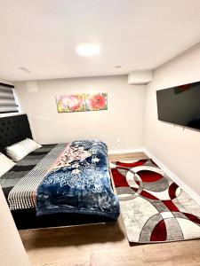 een slaapkamer met een bed en een flatscreen-tv bij Treasure’s Beautiful Basement in Brampton