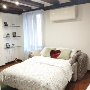 um quarto com uma cama com uma almofada de coração em AL VICOLETTO em Verona