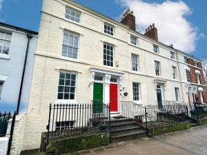 a white building with a red and green door at Shrewsbury 3 Bedroom Abbey Foregate in Shrewsbury
