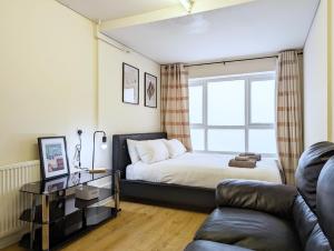 a bedroom with a bed and a couch and a window at Guest Rooms Near City Centre & Dock Free Parking in Liverpool