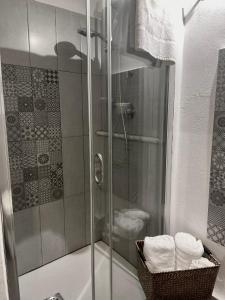 La salle de bains est pourvue d'une douche et d'un panier de serviettes. dans l'établissement Ferienhaus Marlene - Casa Vacanze San Nicola L'Arena, à Trabia