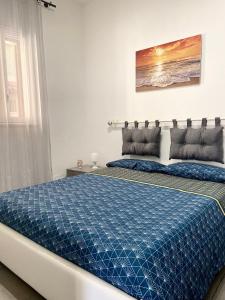 Schlafzimmer mit einem Bett mit blauer Decke in der Unterkunft Ferienhaus Marlene - Casa Vacanze San Nicola L'Arena in Trabia
