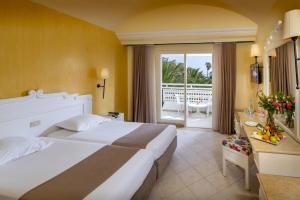 um quarto de hotel com uma cama grande e uma varanda em Mediterranee Hammamet- Families and Couples Only em Hammamet