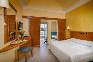 a bedroom with a bed and a desk and a table with fruit on it at Mediterranee Hammamet- Families and Couples Only in Hammamet