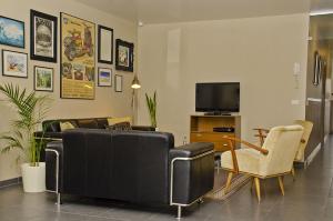 a living room with a couch and chairs and a tv at Hotel Apartments Belgium 1 - HAB 1 in Geel