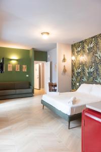 een slaapkamer met een groot bed en een bank bij CASA PEPE ROOMS & APARTMENTS in Trieste