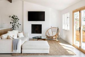 a living room with a white couch and a fireplace at The Broad Beach House in Malibu