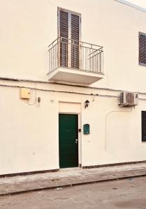 Edificio blanco con puerta verde y balcón en Il Mondo en Catania