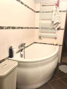 a bathroom with a white tub and a towel rack at Apartament nad rzeką przy parku zamkowym in Olsztyn
