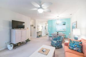 a living room with a couch and a tv at Barefoot Resort - Cypress Bend 123 - Windy Hill in North Myrtle Beach