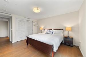 a bedroom with a bed and two lamps on a wooden floor at Park lane 2/2 in Honolulu