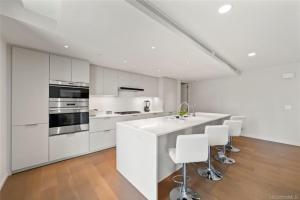 a white kitchen with white appliances and white cabinets at Park lane 2/2 in Honolulu