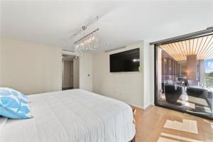 a white bedroom with a large bed and a large window at Park lane 2/2 in Honolulu