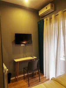 1 dormitorio con escritorio y TV en la pared en Hotel Classic Corner en Tiflis