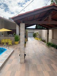 a patio with a pavilion and a pool at Casa Porto in Porto De Galinhas