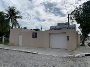 a building with two garage doors and a palm tree at Casa Porto in Porto De Galinhas