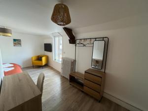 una camera da letto con specchio, letto e tavolo di Proche château - Calme, Confortable, Tout équipé a Fougères