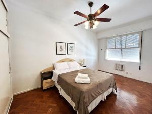 um quarto com uma cama e uma ventoinha de tecto em BN13 - Apto Espaçoso a 4 min da praia Copacabana no Rio de Janeiro
