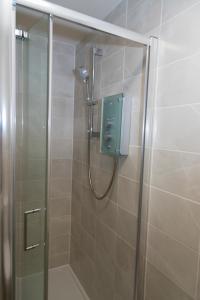 y baño con ducha y puerta de cristal. en Spacious New Build - Free Parking & TV in each Bedroom, en Macclesfield