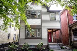a house with white siding and a red door at OSU and Short North 4 Bedroom Patio and Garage with EV in Columbus