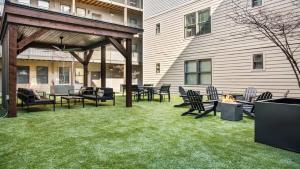 a patio with chairs and tables and a fire pit at TWO CozySuites Stylish Music Row Condos w parking in Nashville