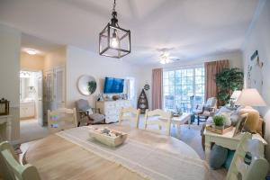 a dining room and living room with a table and chairs at Barefoot Resort - Arbor Trace 523 - Windy Hill in North Myrtle Beach +15 photos
