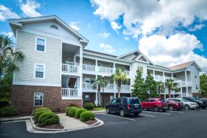 a large building with cars parked in a parking lot at Barefoot Resort - Arbor Trace 523 - Windy Hill in North Myrtle Beach