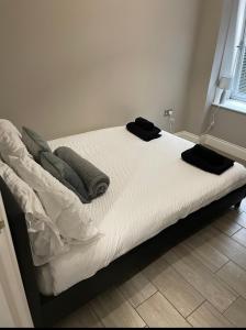 un letto con lenzuola e cuscini bianchi di City Centre Seaview Apartment a Brighton & Hove